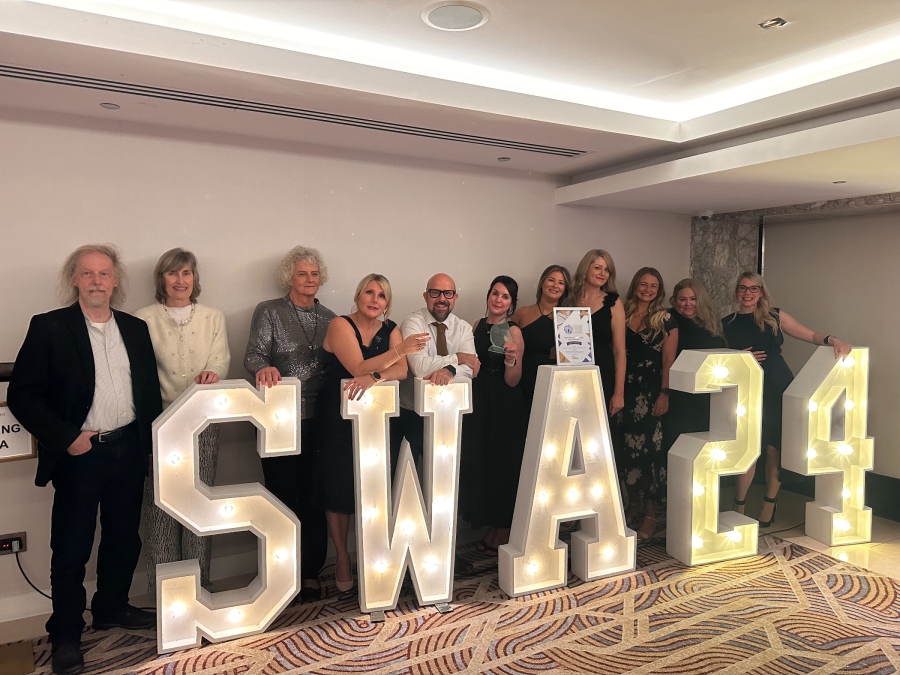 social work colleagues stood infront of sign smiling